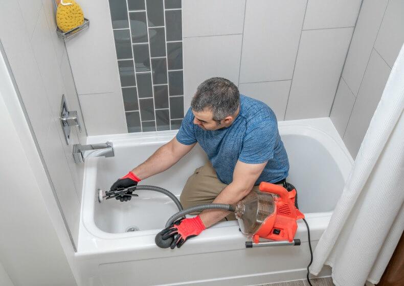 homeowner pouring chemical drain cleaner down kitchen sink in Alamo
