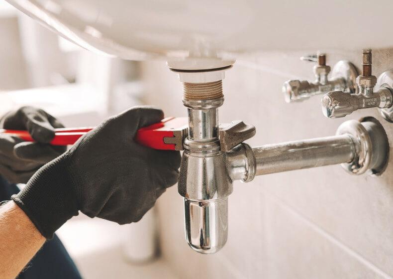 plumbers repairing a water leak with specialized tools